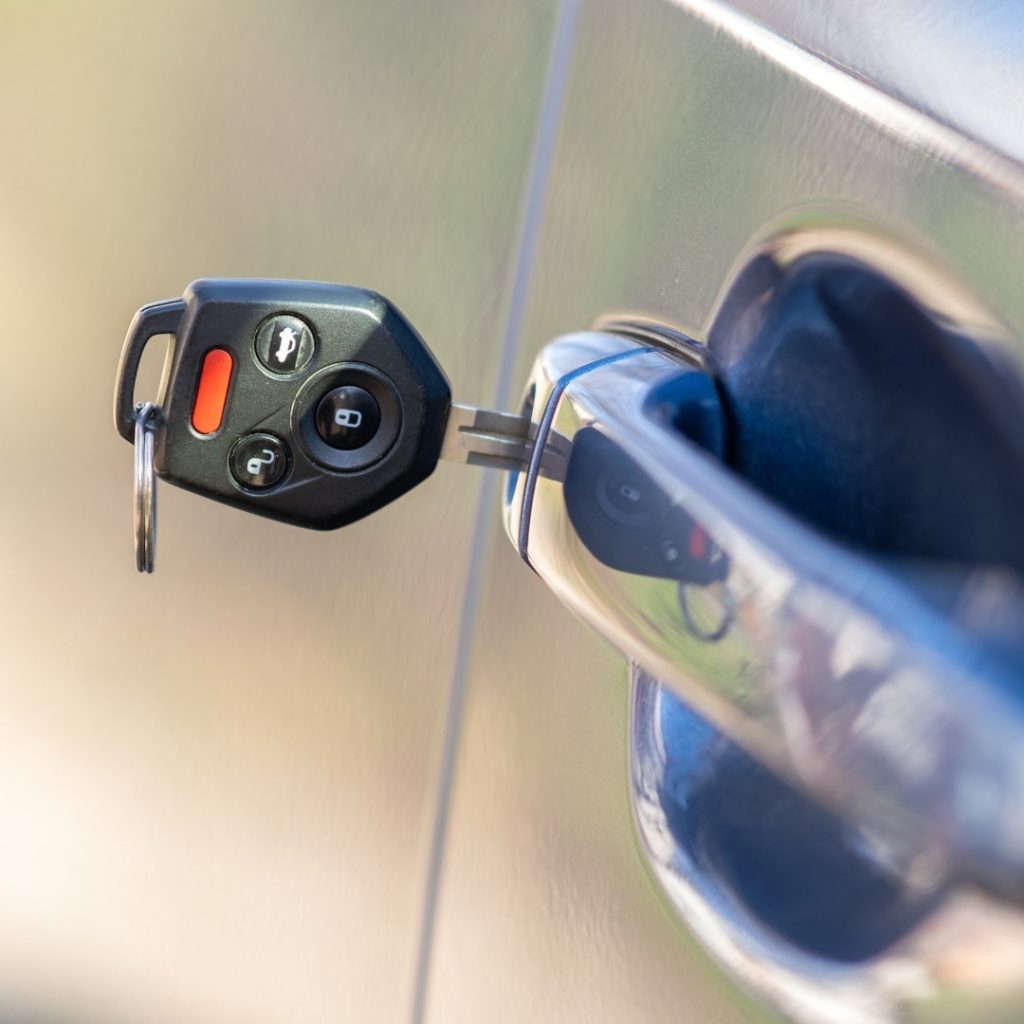 Close up of Car Door with Key Sticking Out of the Lock Concept of Process Opening or Closing Vehicle