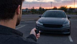 Residential Locksmith 11 Driver pressing a car key fob that is not working in a parking lot